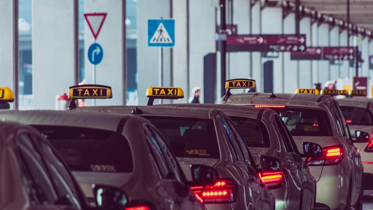 Rij taxi’s wachtend bij een overdekte standplaats, passend bij werken in het personenvervoer