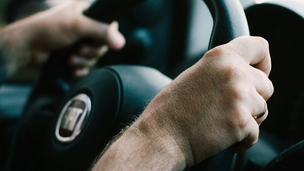 Handen van leerling aan het stuur tijdens een rijles, onderdeel van een rijlespakket met focus op voertuigbeheersing en praktijkervaring